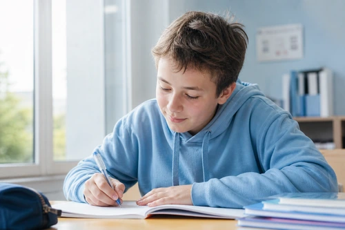 Enfant concentré et serein sur ses devoirs après suivi en intégration des réflexes archaïques à Brest